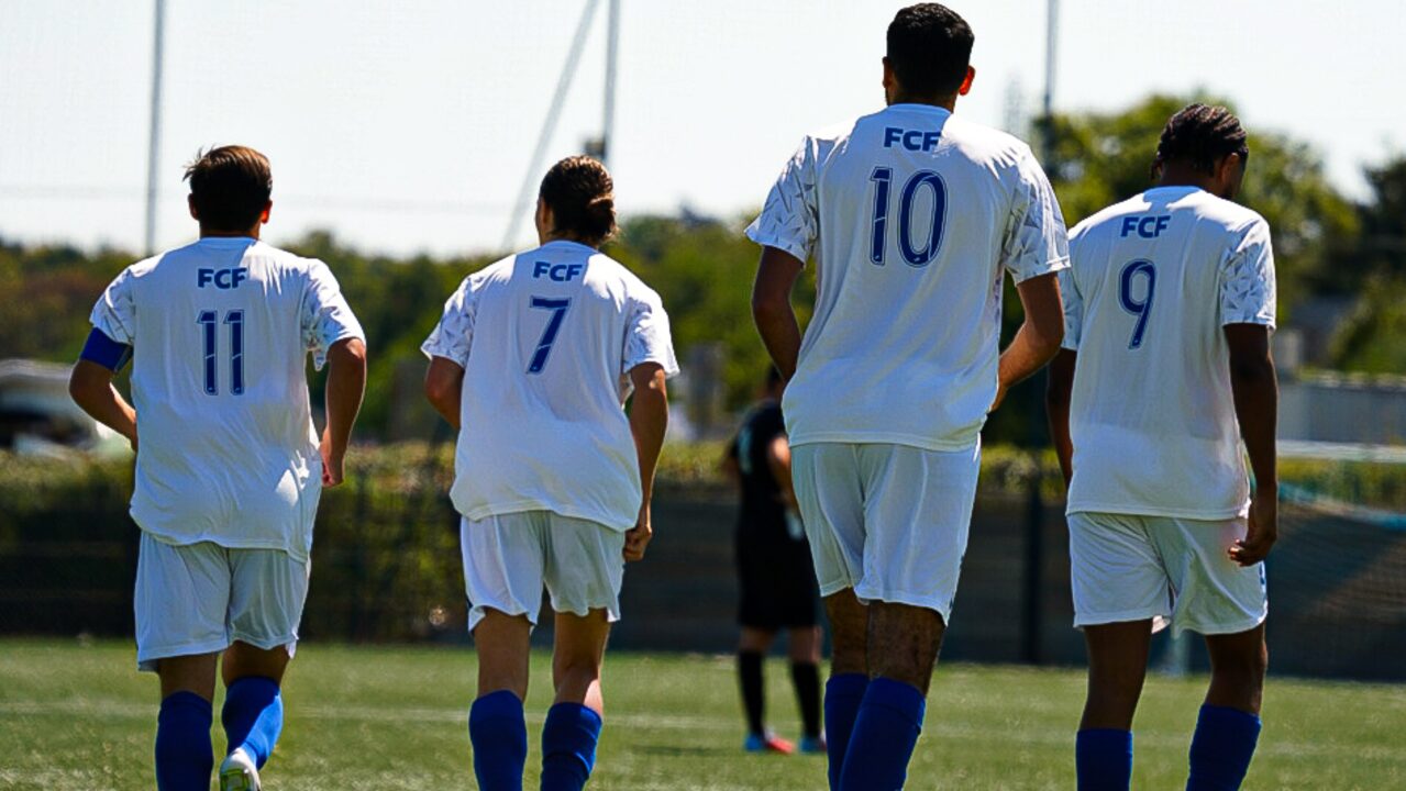 Joueurs du FC Franchevillois sur le terrain, maillots blancs floqués FCF